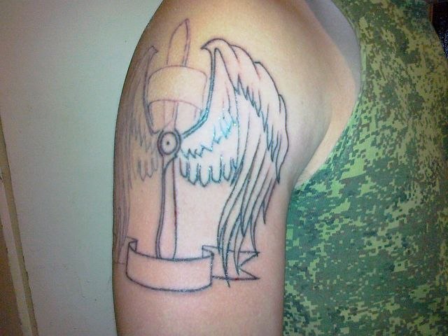 Недоделанная татуировка на плече винта с крыльями