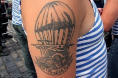 Татуировка на плече с изображением самолета и парашюта