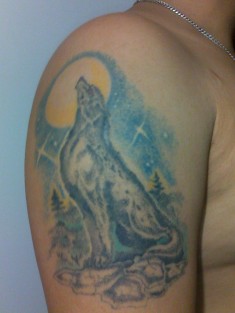 Цветная татуировка на руке «Воющий волк на луну»