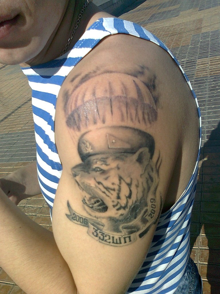 Татуировка на плече с изображением головы тигра и купола парашюта